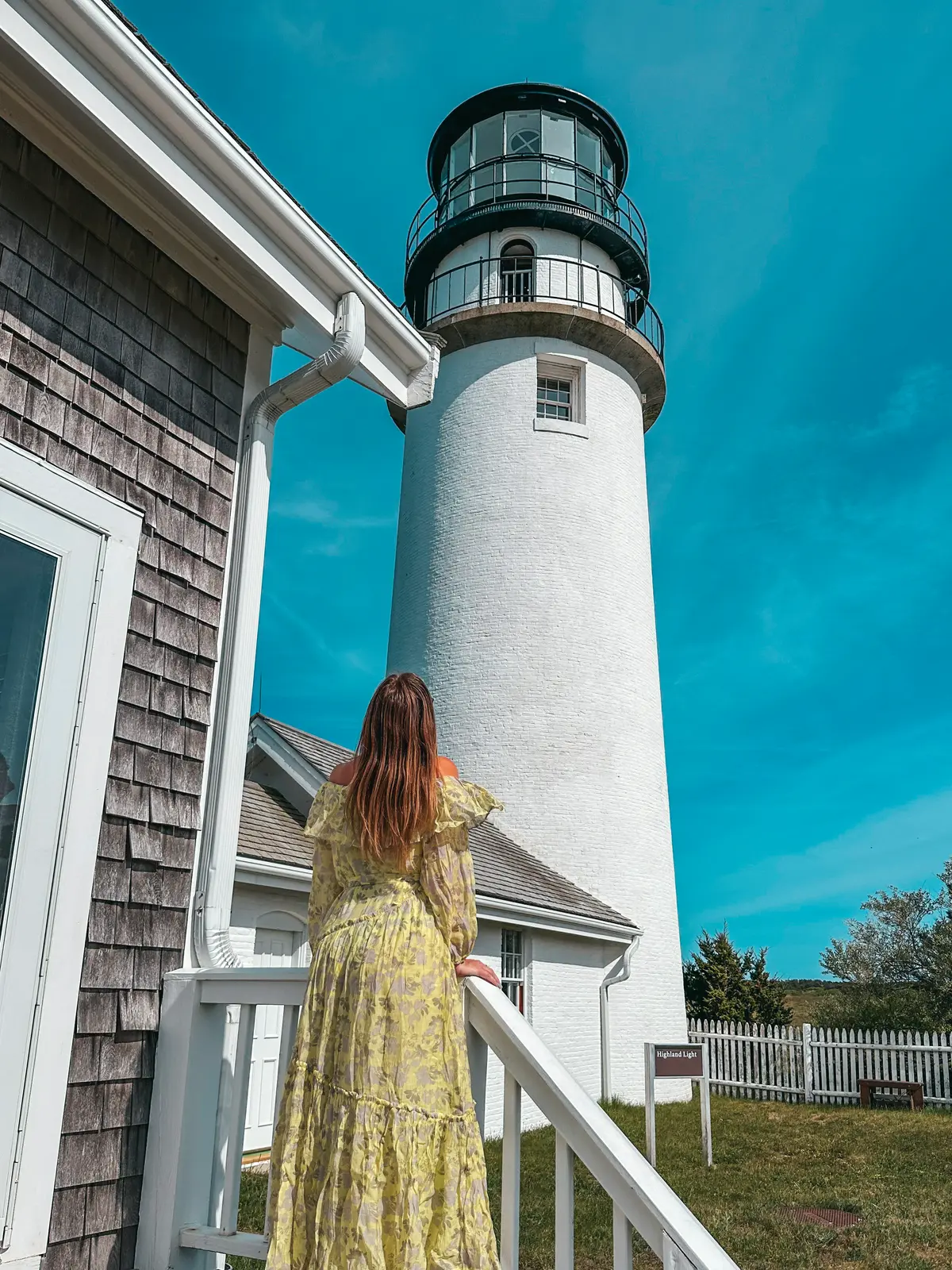 Woman looking up at Highland Light on Cape Cod