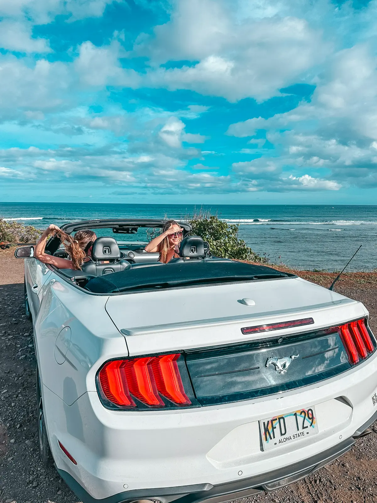 Friends sitting in a convertible on Kauai