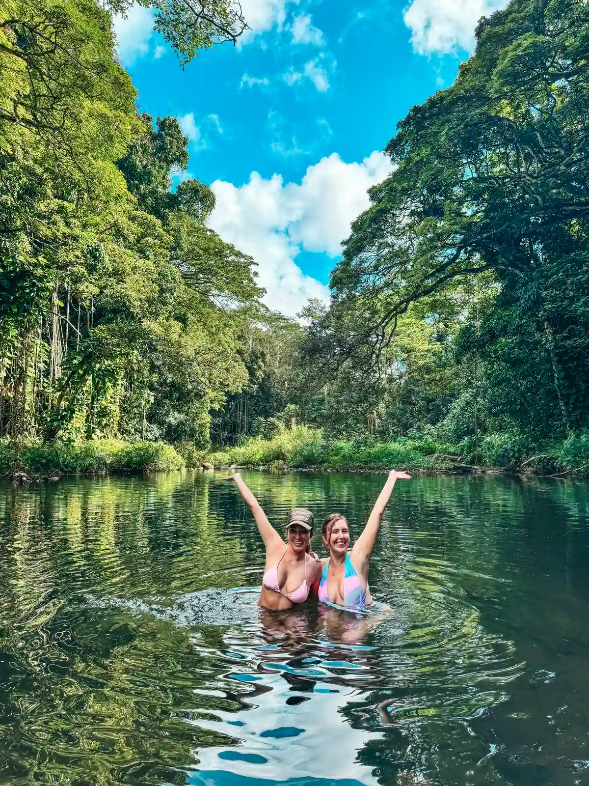 Friends swimming at Ho‘opi‘i Falls on Kauai