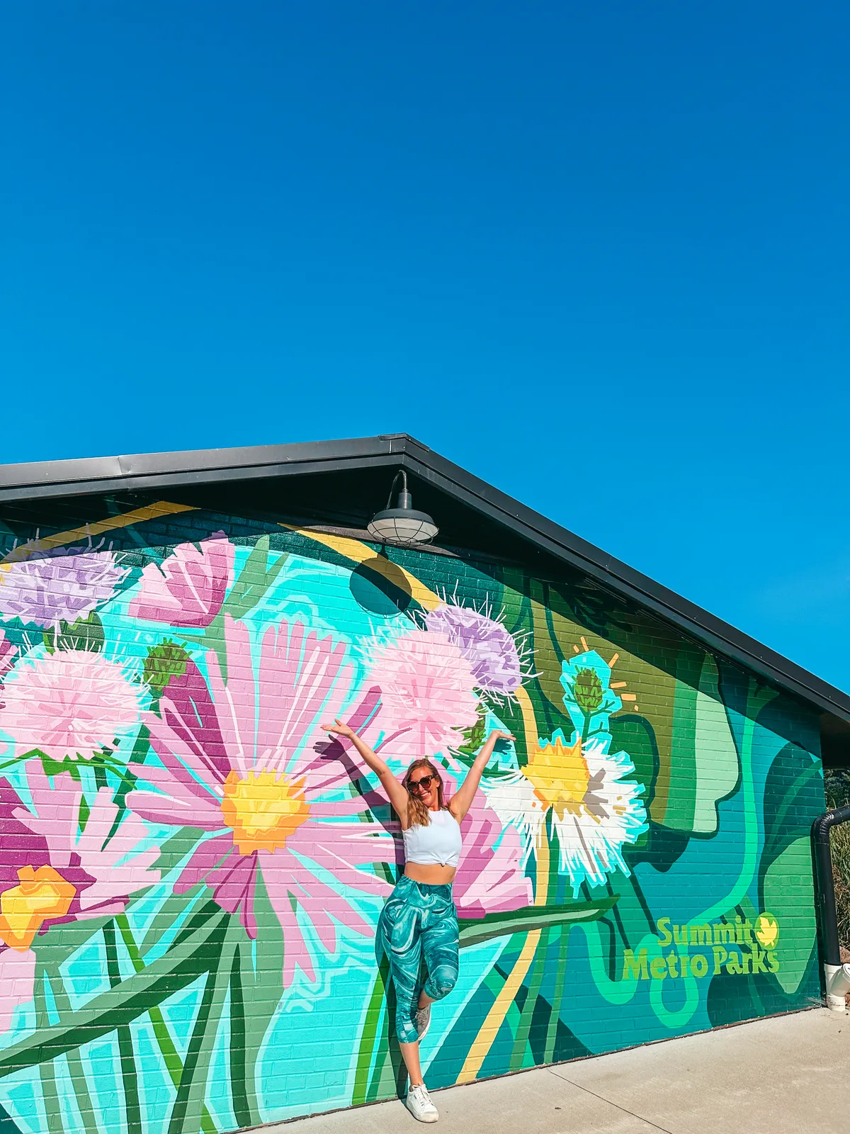 Woman posing with flower mural at Summit Metro Parks in Ohio