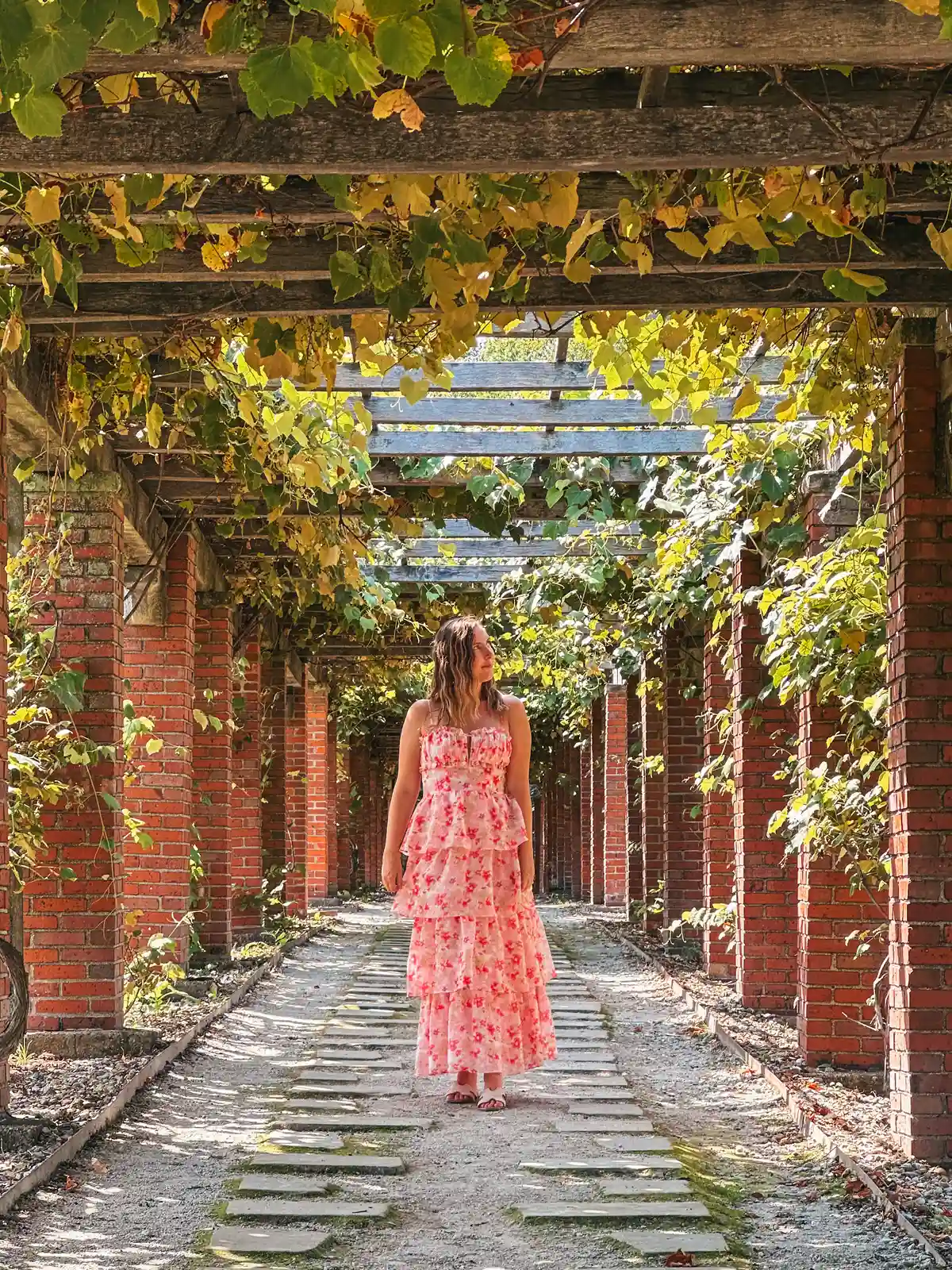 Woman walking under pergola at Stan Hywet Hall and Gardens in Akron Ohio