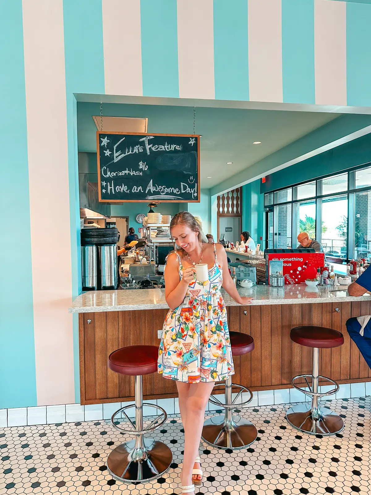 Woman holding coffee at Ella Mae’s Diner in Fort Myers Florida