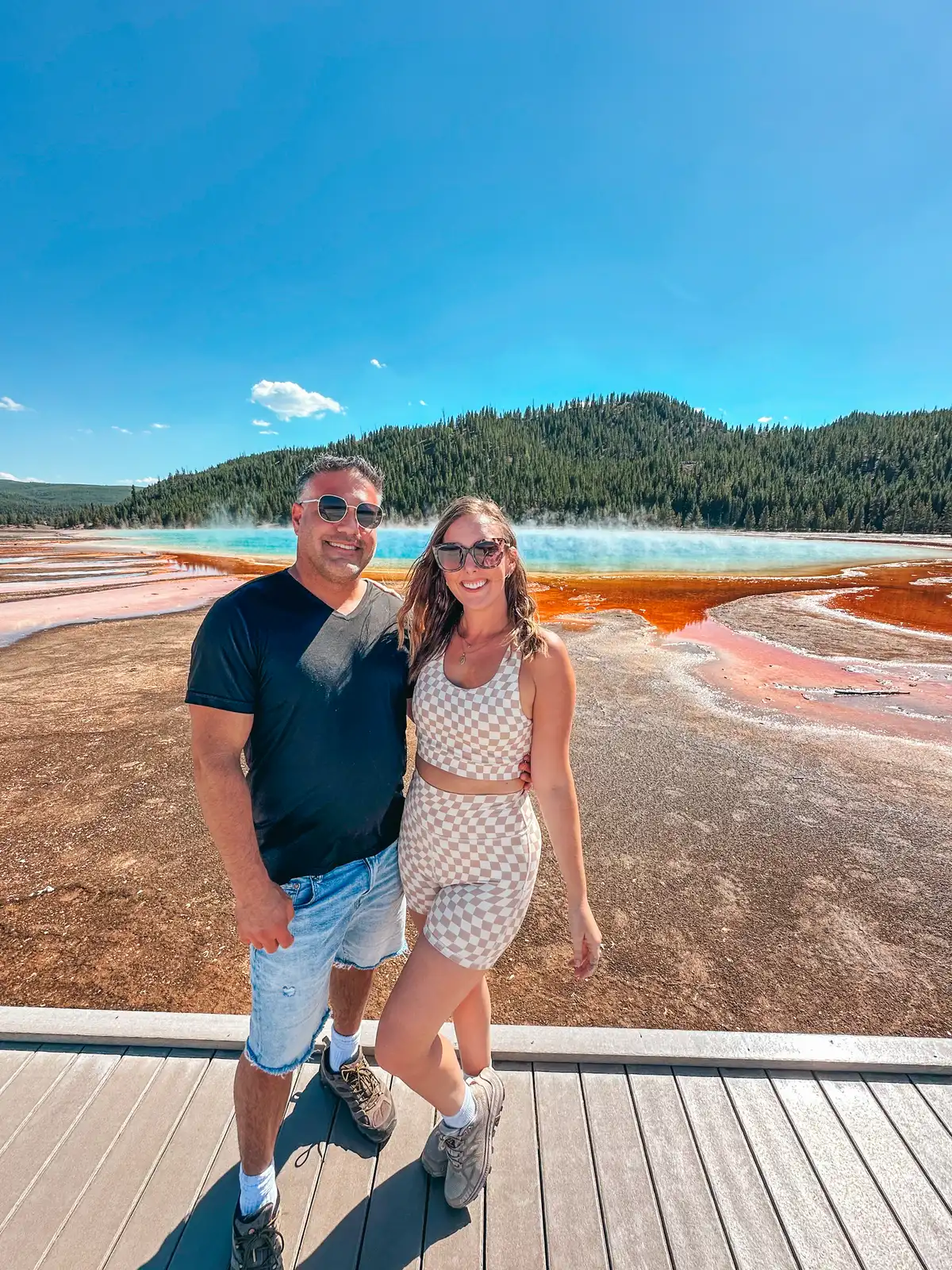 Couple In Front Of Grand Prismatic At Yellowstone Nationai Park