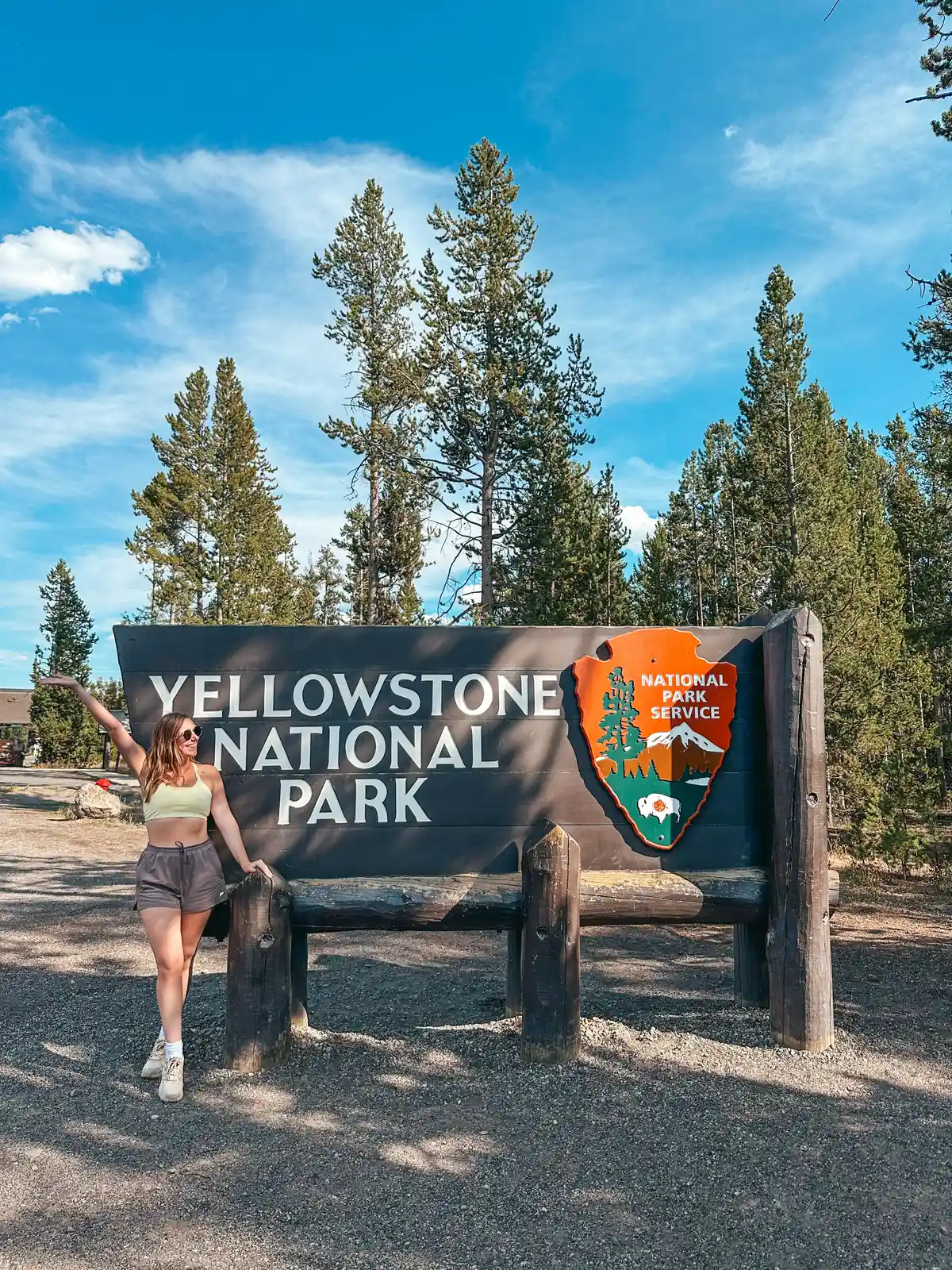 Woman Posing In Front Of Yellowstone National Park Entrance Sign