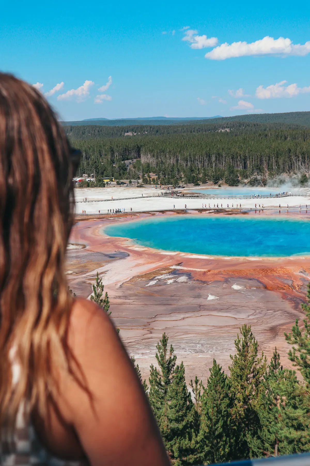Woman Viewing Vibrant Colors Of Grand Prismatic In Yellowstone National Park From The Fairy Falls Trail Viewpoint