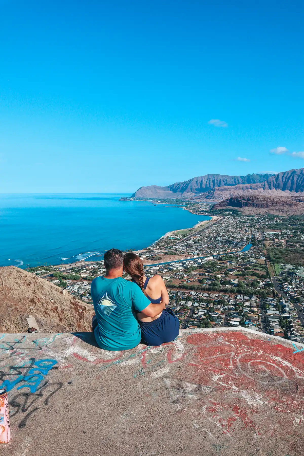 Couple Sitting At The Top Of The Pink Pillbox Trail On Oahu