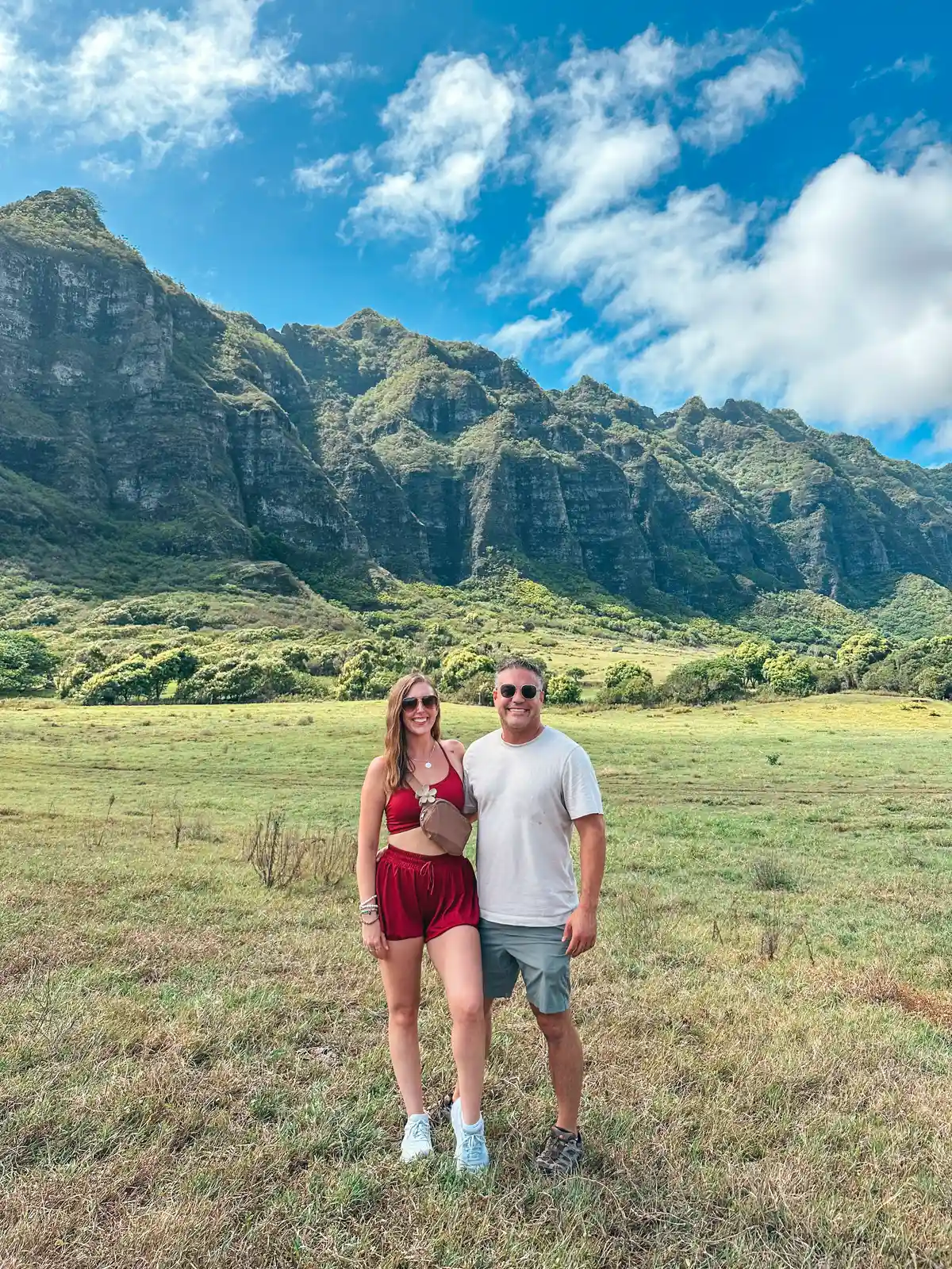 Couple Standing In Front Of Beautiful Mountain Range At Kualoa Ranch In Kaneohe