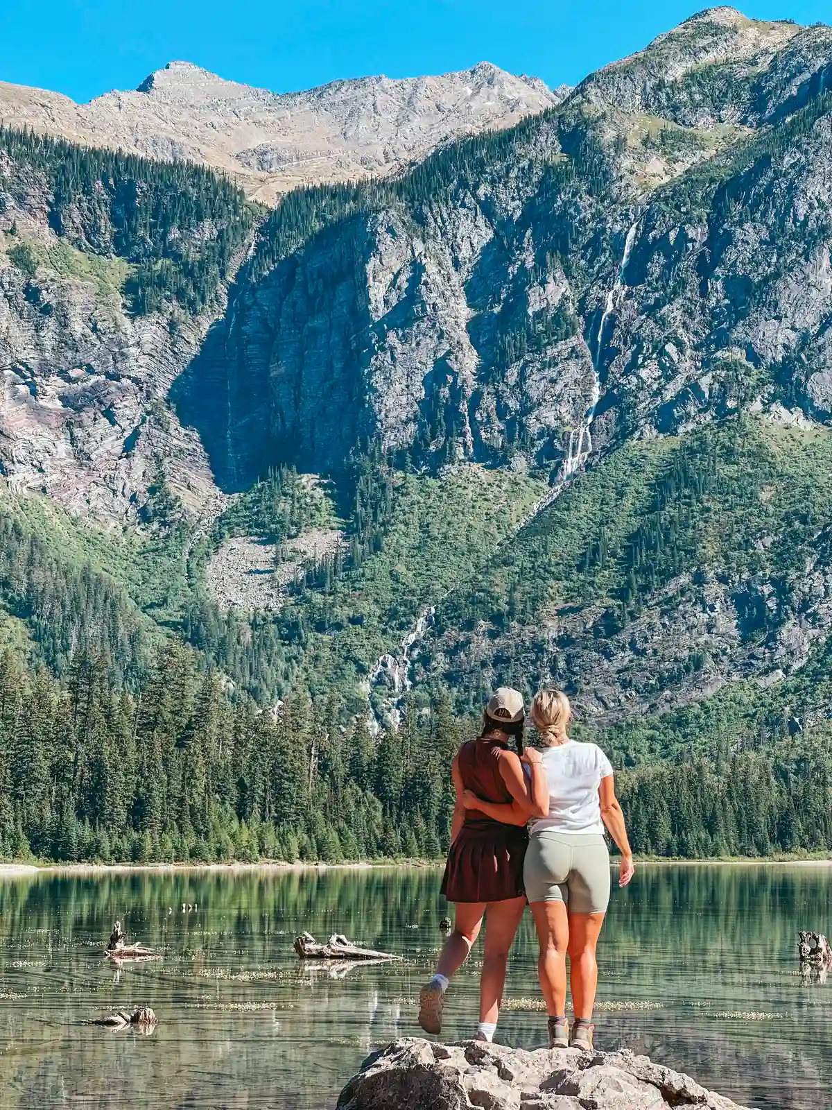 Friends Posing At Avalanche Lake In Glacier National Park