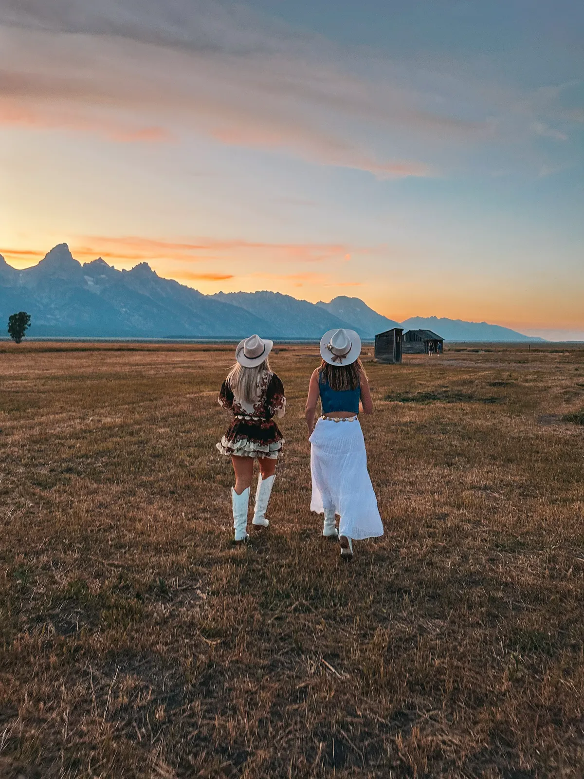 Friends Running Through A Field At Mormon Row In Grand Teton National Park