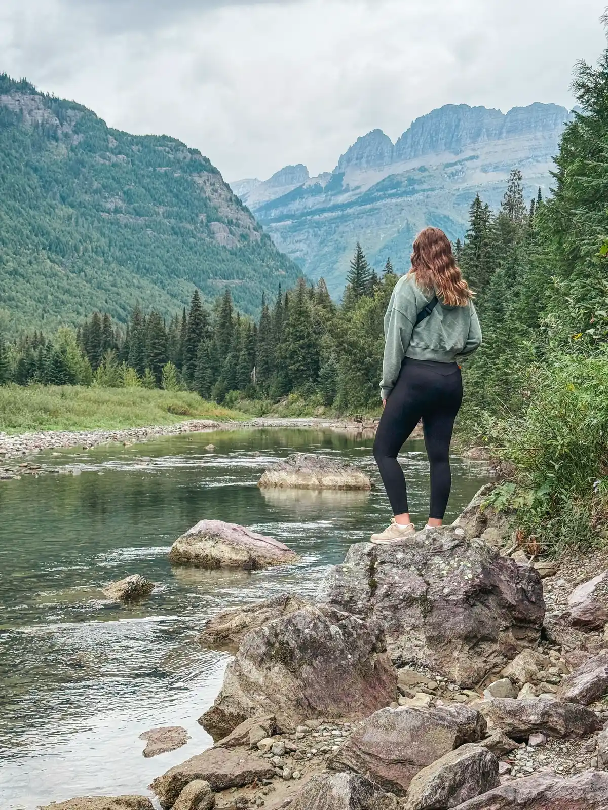 Woman Looking Out At McDonald Creek In Glacier National Park