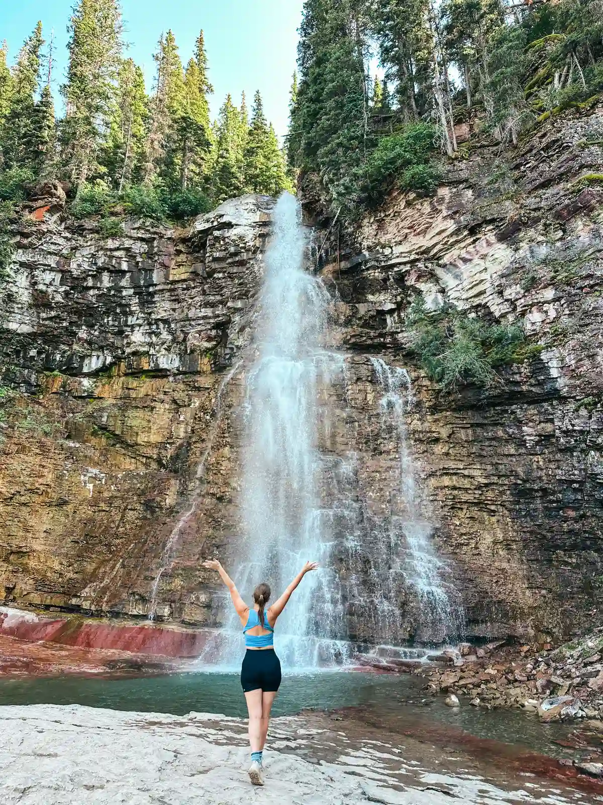 Woman Standing In Front Of Virgina Falls At Glacier National Park